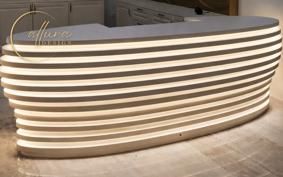 Birou de recepție curbat, construit din straturi suprapuse cu lumină caldă între ele